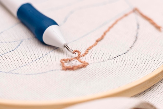 Mână brodând un model delicat